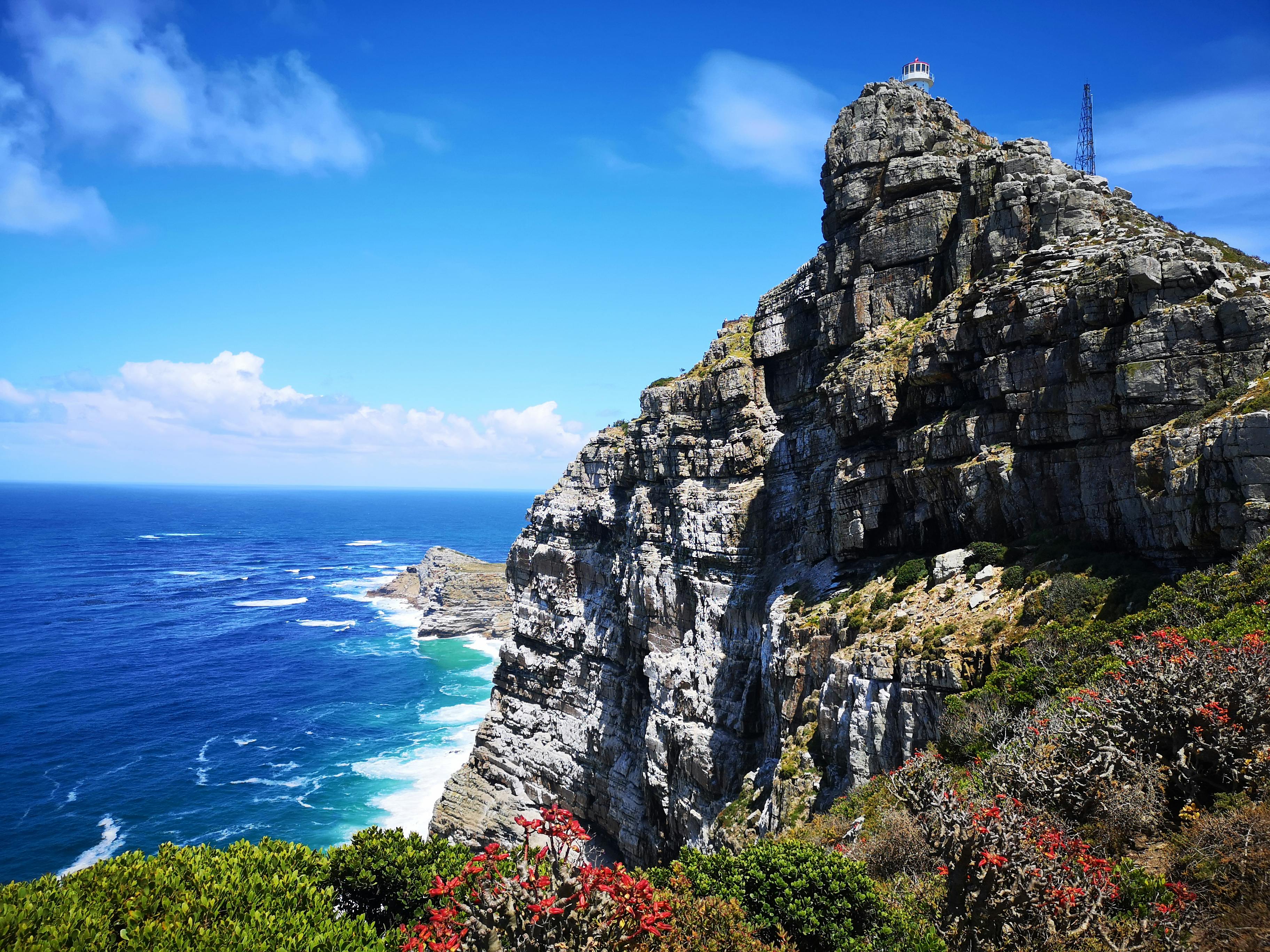 Cape Point lighthouse above sheer cliffs meeting the Atlantic Ocean